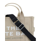 Marc Jacobs beige cotton handbag with structured design and top handles, featuring subtle branding and minimalist style.