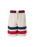 Gucci cream polyester logo shorts with Gucci branding and a relaxed fit, displayed on a plain background.