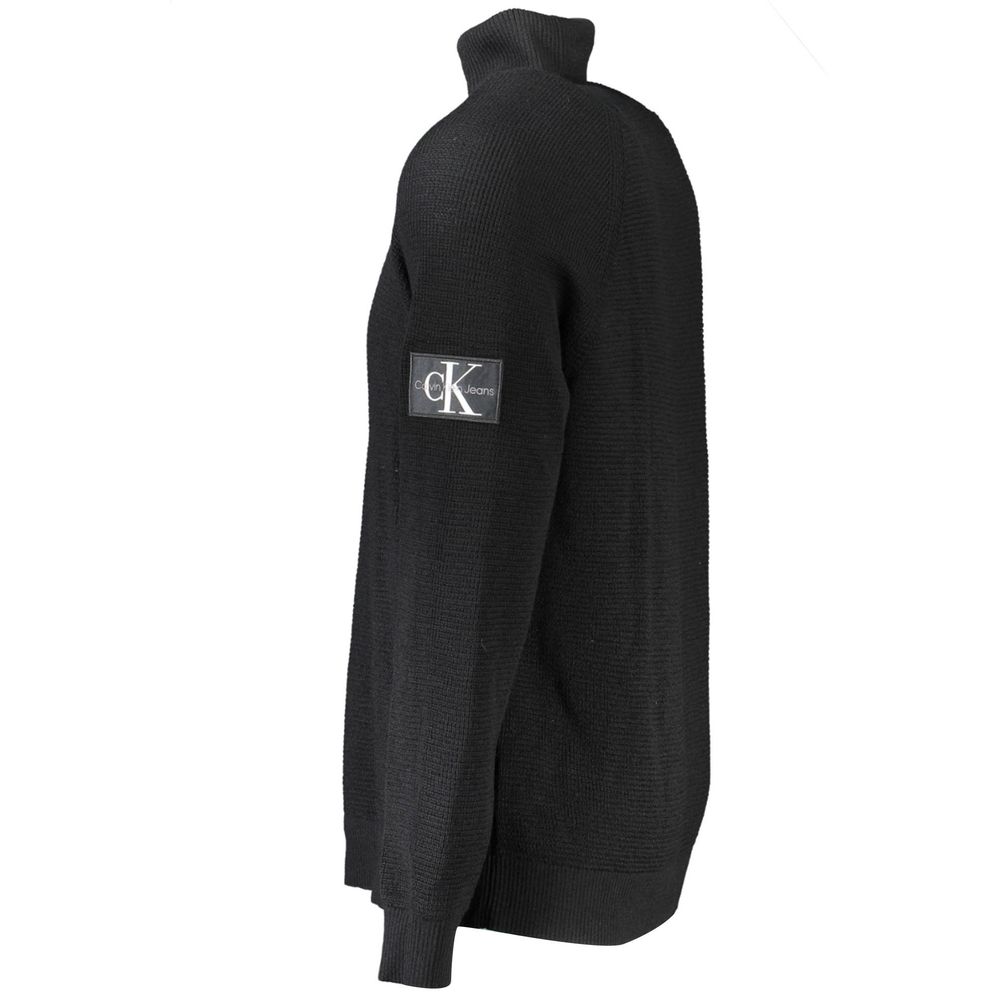 Black wool men's sweater by Calvin Klein, featuring a crew neck and ribbed cuffs, displayed on a neutral background.