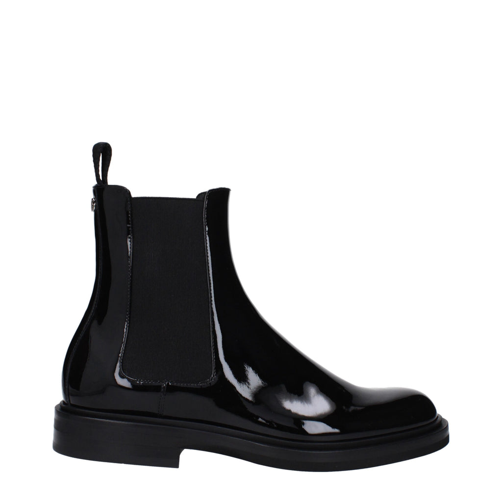 Black leather ankle boots by Dolce & Gabbana with sleek design and pointed toes, showcased on a neutral background.