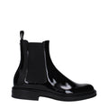 Black leather ankle boots by Dolce & Gabbana with sleek design and pointed toes, showcased on a neutral background.