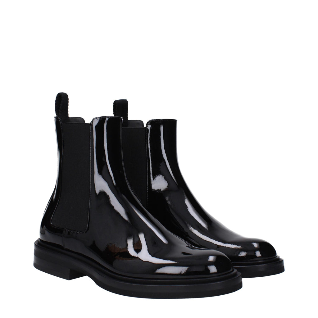 Black leather ankle boots by Dolce & Gabbana with sleek design and pointed toes, perfect for stylish everyday wear.