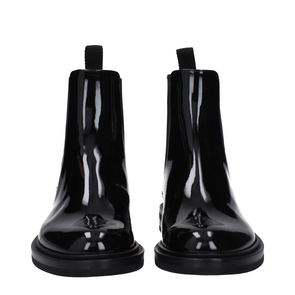 Black leather ankle boots by Dolce & Gabbana with sleek design and pointed toes, stylish footwear for sophisticated outfits.