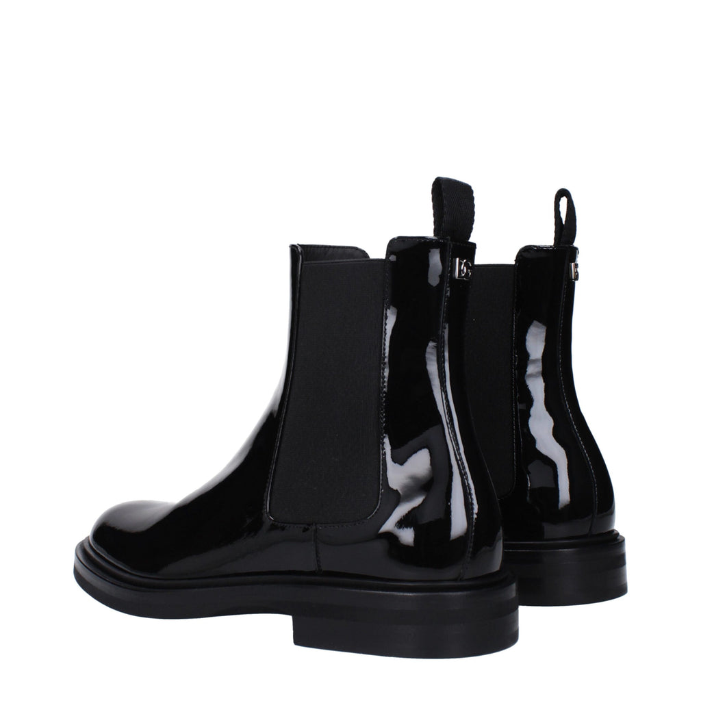 Black leather ankle boots by Dolce & Gabbana with sleek design and pointed toes, showcased on a neutral background.