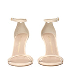 Stuart Weitzman beige leather stiletto heel sandals with ankle straps and open toe design.