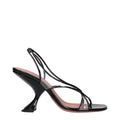 Black leather stiletto heel sandals by Amina Muaddi, featuring sleek straps and elegant design.