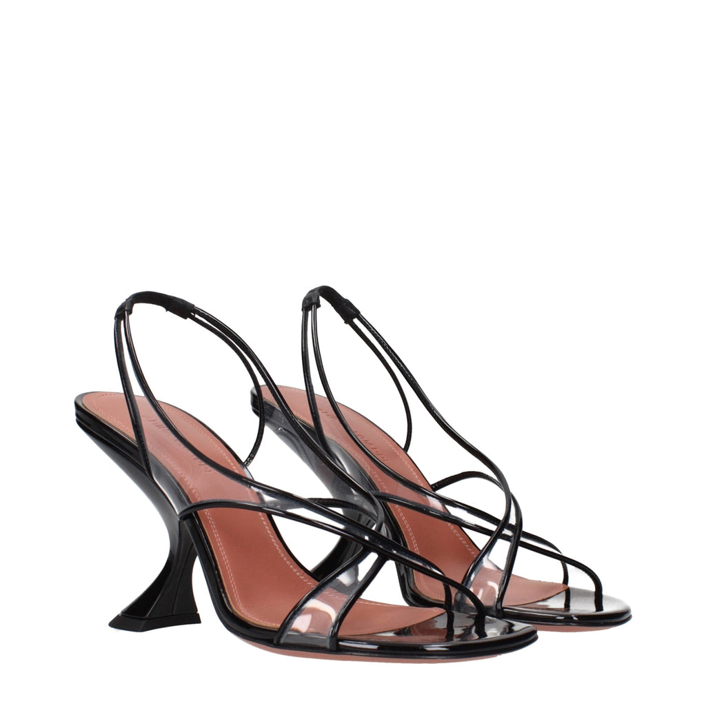 Amina Muaddi black leather stiletto heel sandals with sleek straps and pointed toes on a white background.