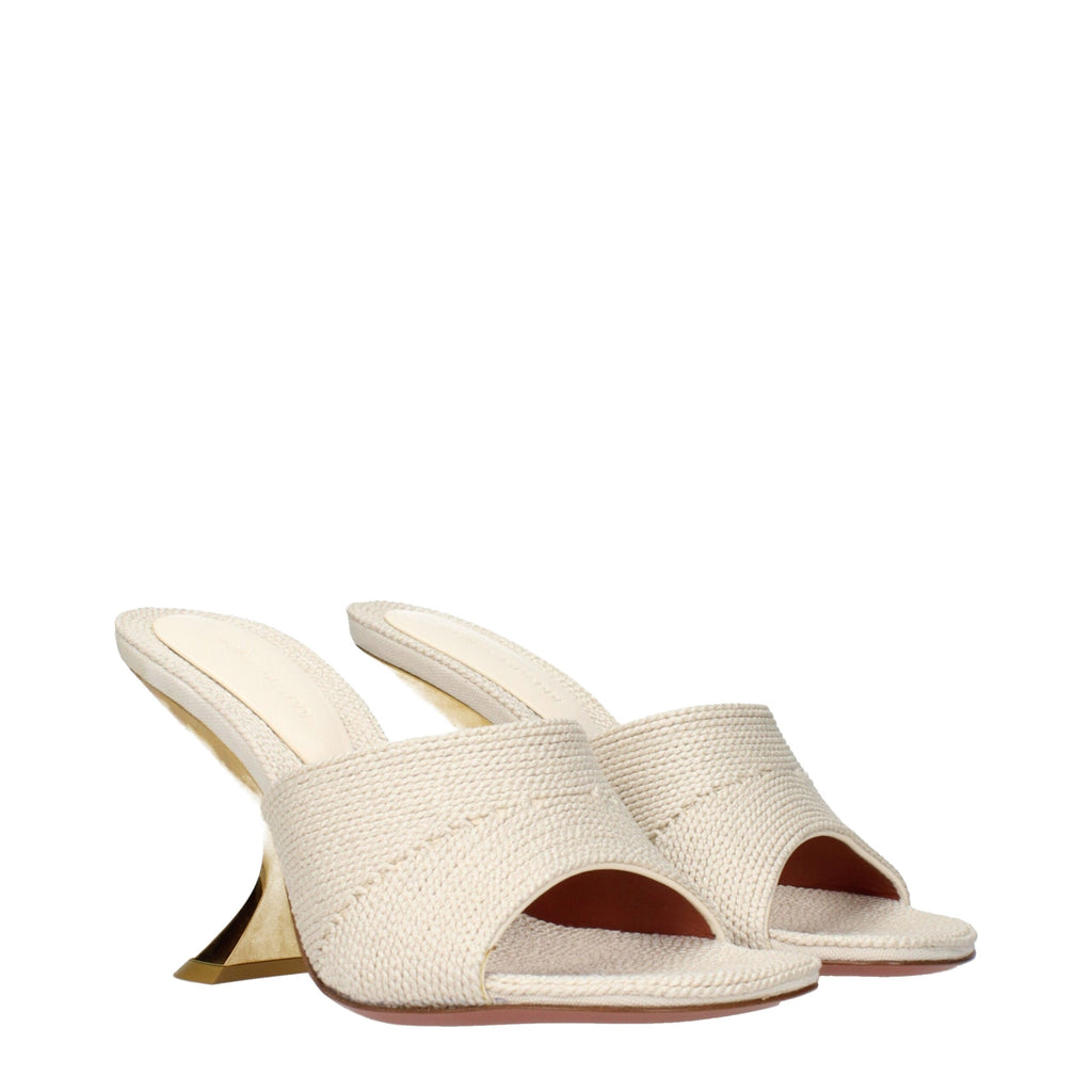 Amina Muaddi beige fabric slippers with sleek design and pointed toes, featuring elegant stitching and a comfortable flat sole.