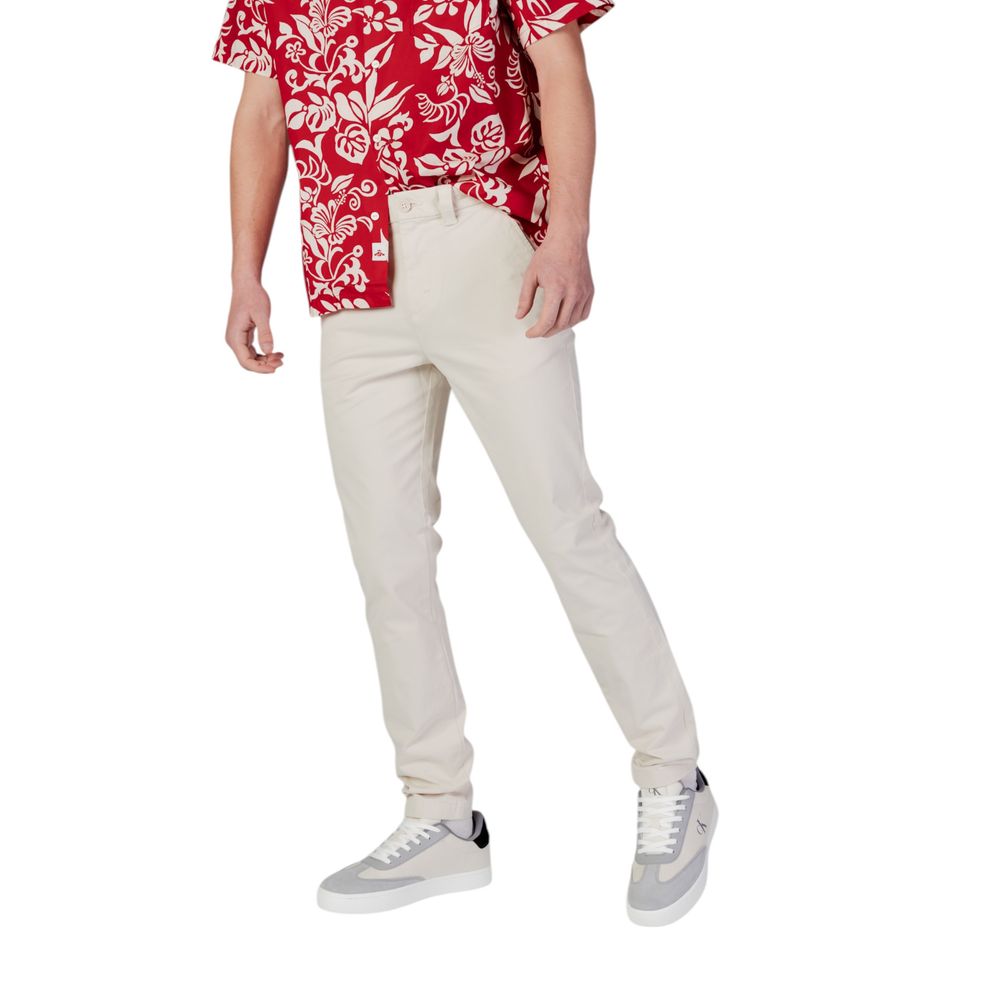 Beige cotton skinny jeans from Tommy Hilfiger Jeans, shown on a model, featuring classic five-pocket design and slim fit style.
