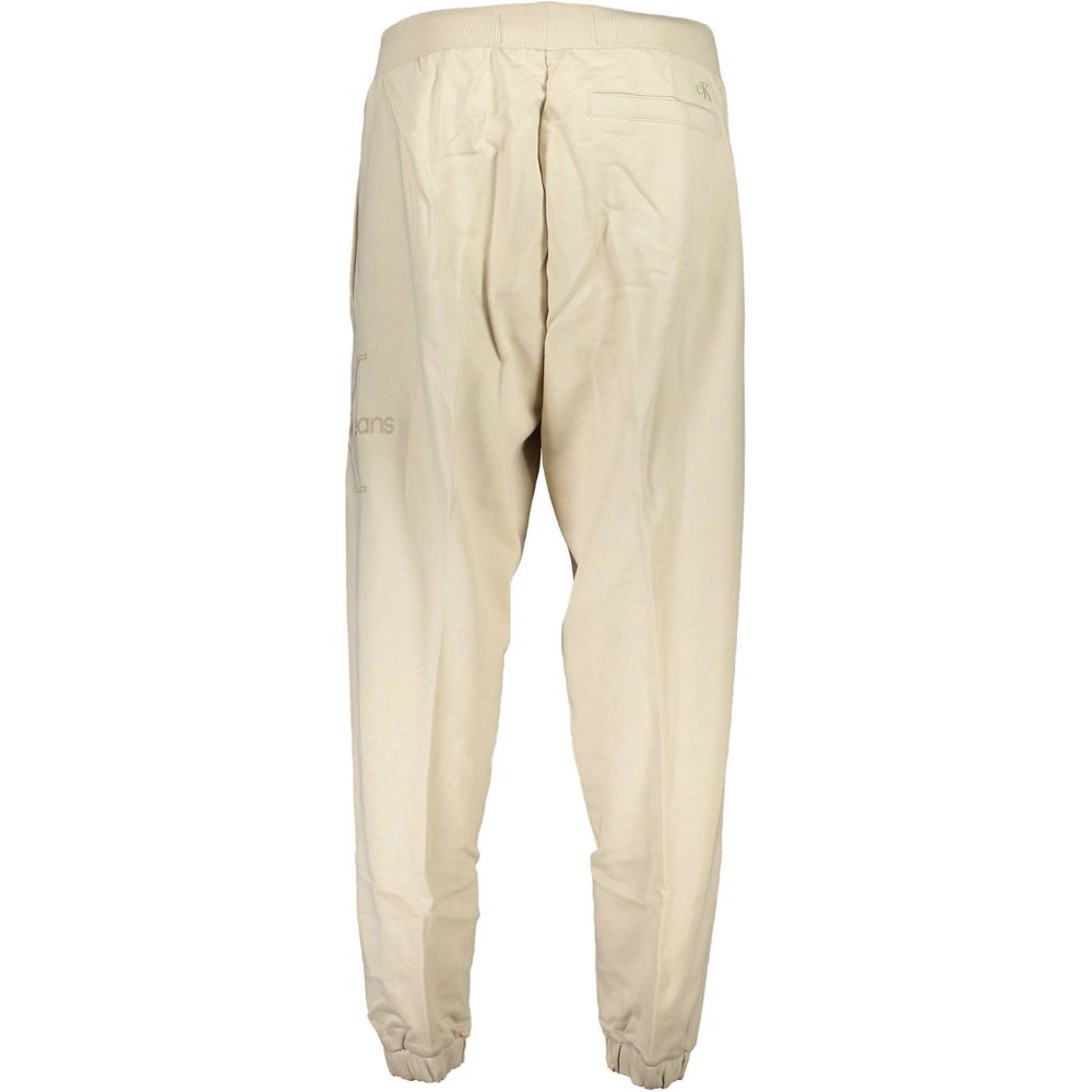 Beige cotton men's sweatpants by Calvin Klein, comfortable casual clothing with elastic waistband and relaxed fit.