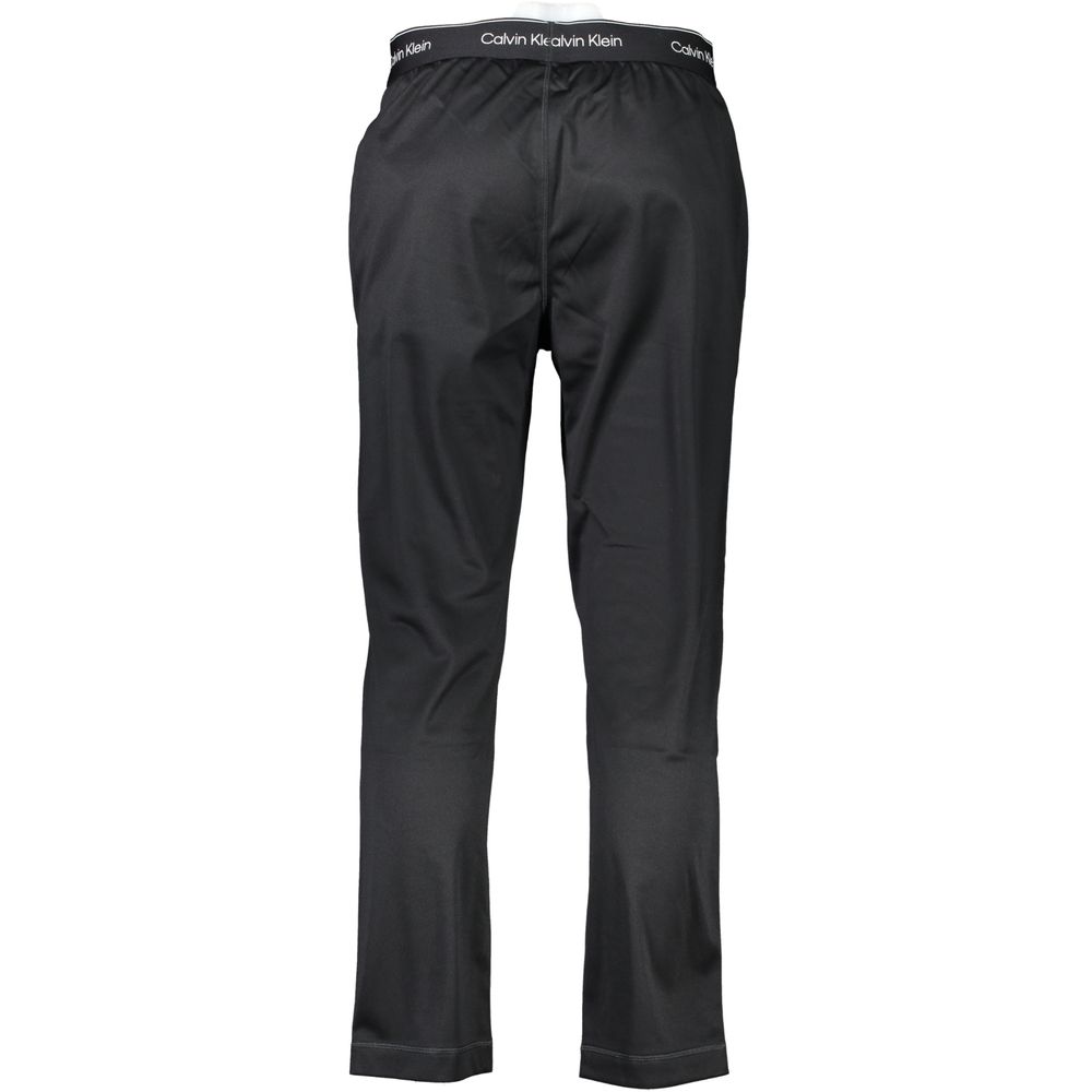 Calvin Klein black polyester men's track pants with elastic waistband and side pockets, casual athletic wear.