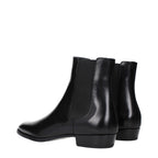 Black leather ankle boots by Celine with sleek design and pointed toes, featuring subtle stitching and low block heels.