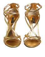 Dolce & Gabbana Gold Leather Keira Heels sandals with open toes and ankle straps on a white background.
