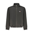 Tommy Hilfiger black polyester men's jacket with front zipper and collar, displayed on a hanger.