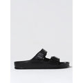 Black EVA flat sandals by Birkenstock with adjustable strap and open toe design, suitable for casual wear.