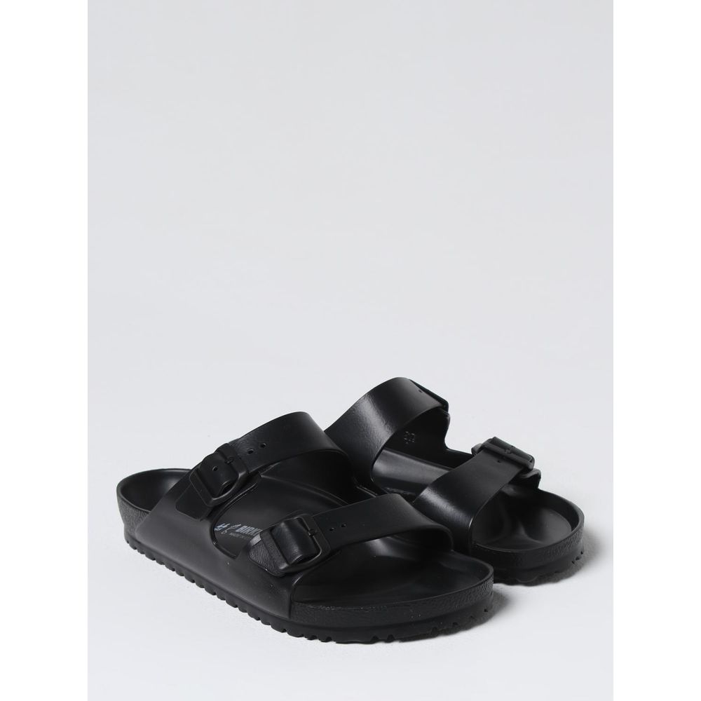Black EVA Birkenstock flat sandals with open toe design and adjustable strap, featuring cushioned footbed for comfort.