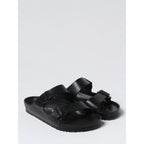 Black EVA Birkenstock flat sandals with open toe design and adjustable strap, featuring cushioned footbed for comfort.