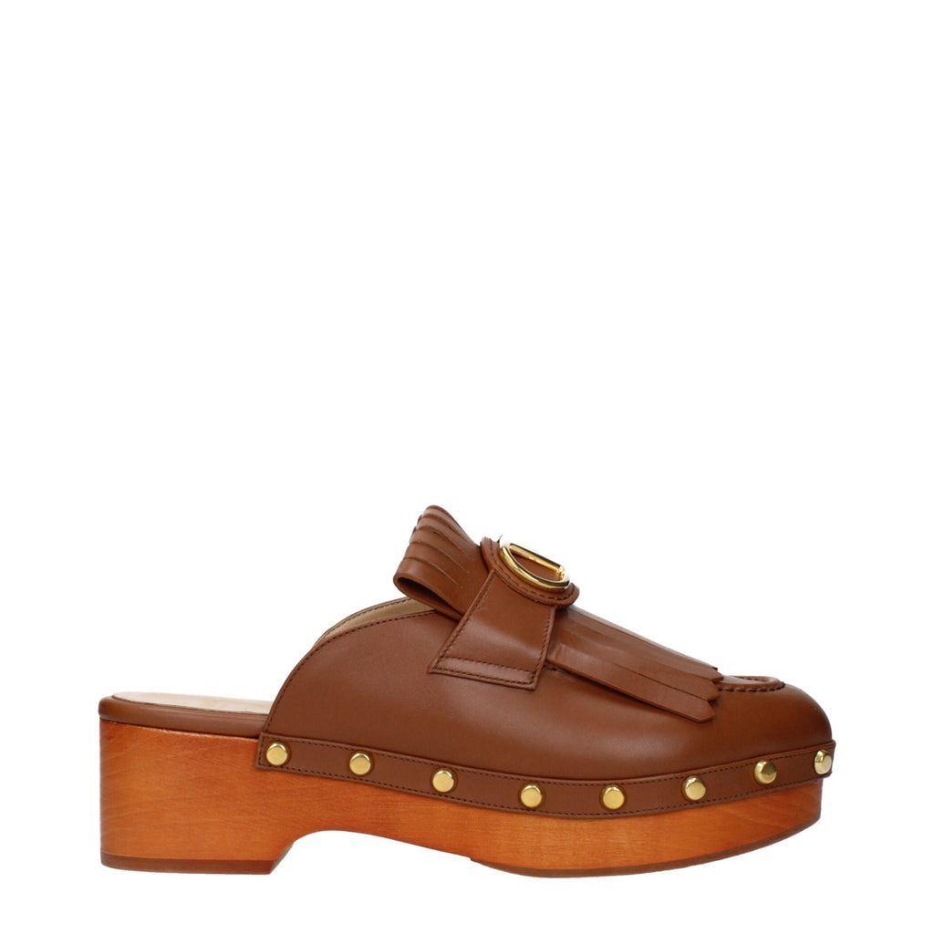 Brown leather slippers by Valentino Garavani featuring a sleek, minimalist design and comfortable slip-on style.