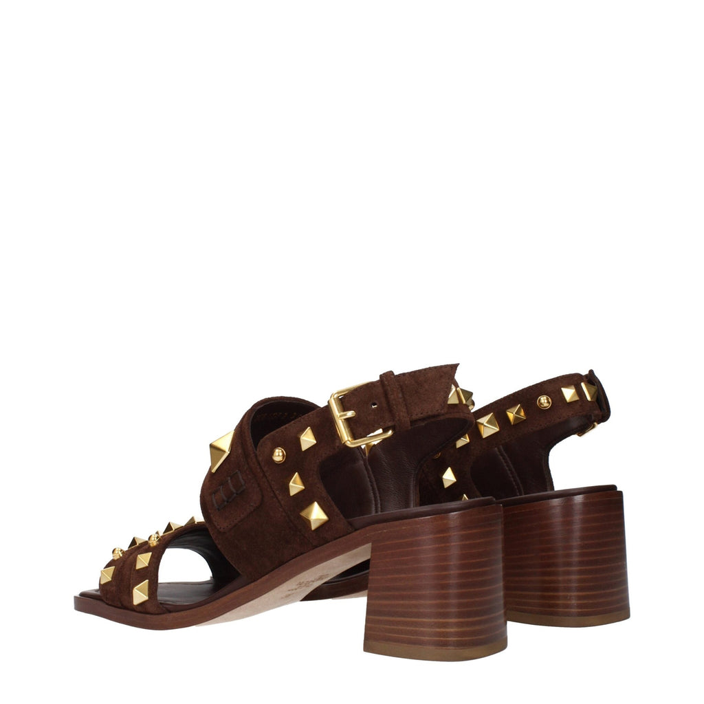 Brown leather strap-on sandals by Valentino Garavani featuring open toes and ankle straps on a neutral background.