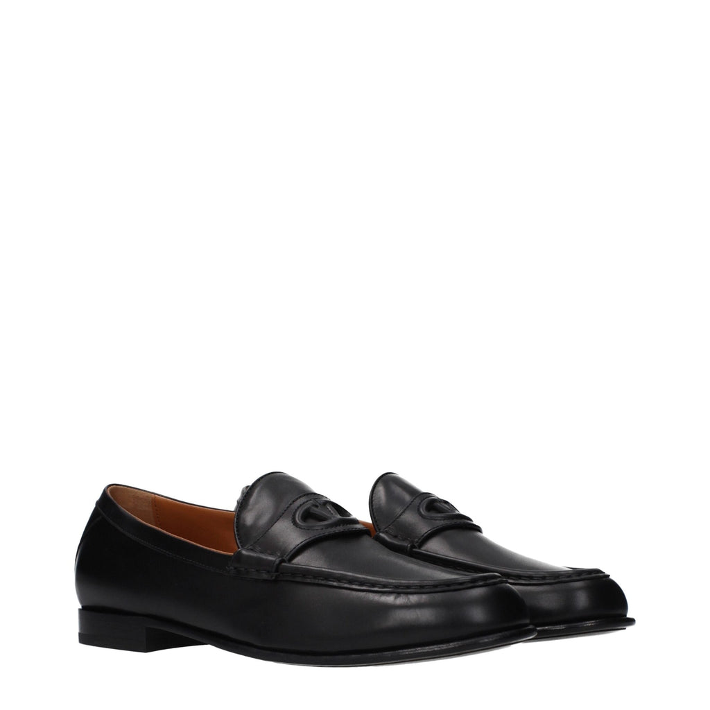 Black leather slip-on loafers by Valentino Garavani with sleek design and subtle logo detail, perfect for stylish casual wear.